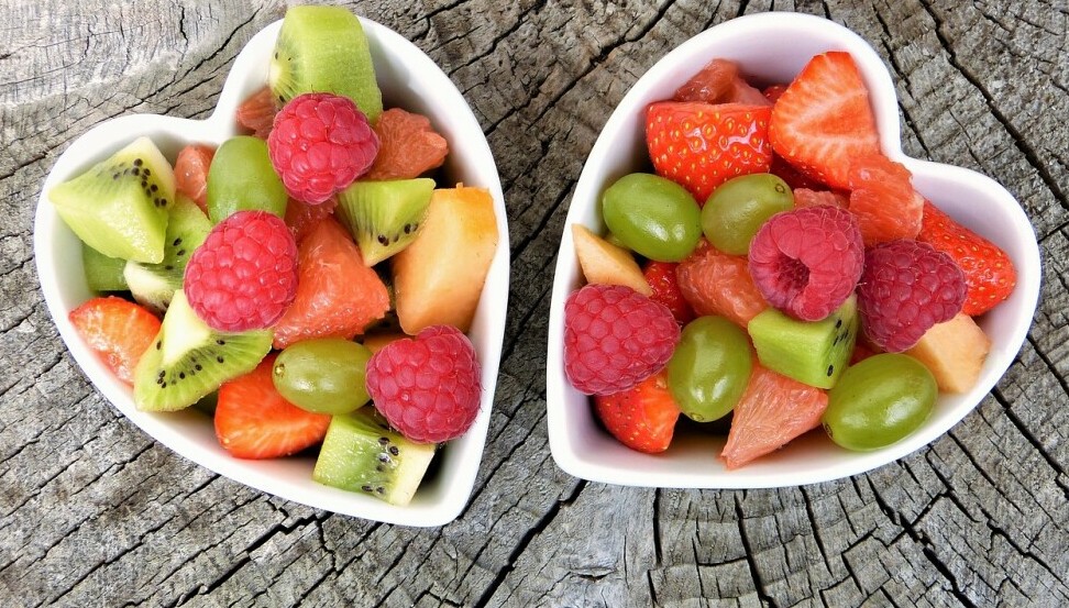 two heart-shaped bowls filled with various fruits